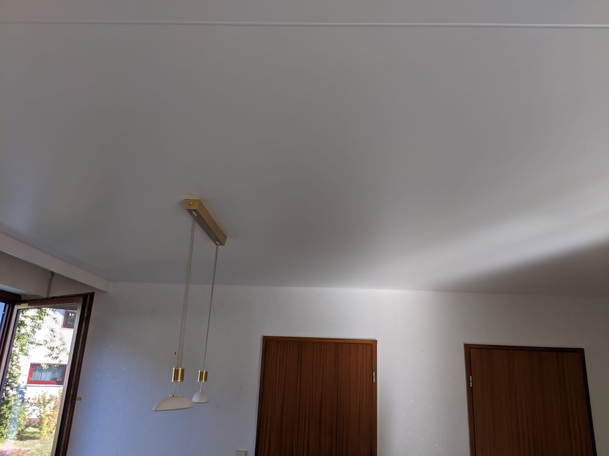 Satin Spanndecke im Esszimmer mit goldener Beleuchtung. 